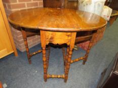 A SMALL ANTIQUE OAK DROPLEAF TABLE WITH BOBBIN TURNED SUPPORTS