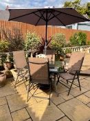 A GLASS TOPPED GARDEN TABLE WITH 4 CHAIRS AND A PARASOL IN USED CONDITION A/F