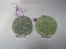 TWO CHINESE JADE CARVED AND PIERCED CIRCULAR PENDANTS, both with typical pierced carved
