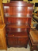 A REPRODUCTION MAHOGANY OPEN WATERFALL BOOKCASE WITH A TWIN DOOR CUPBOARD BELOW H-149 W-70 CM