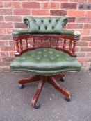 A REPRODUCTION GREEN LEATHER SWIVEL ARMCHAIR - DAMAGE TO ARMS