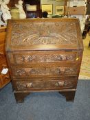 AN ANTIQUE CARVED OAK BUREAU WITH LION MASKS H-102 W-75 CM