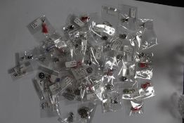 A LARGE QUANTITY OF PACKAGED SILVER CHARMS (50)