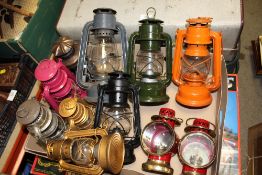 A COLLECTION MULTICOLOURED TILLEY LAMPS