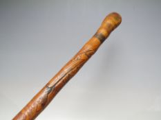 A VINTAGE ORIENTAL CARVED WAKING CANE WITH ROOT BALL KNOP, the shaft having typical carved
