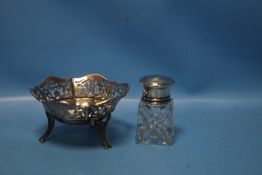 A HALLMARKED SILVER PIERCED BASKET, together with a silver topped bottle (2)