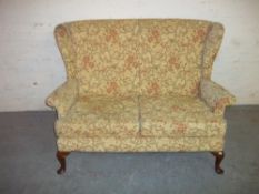 A FABRIC TWO SEATER SOFA WITH QUEEN ANN STYLE LEGS