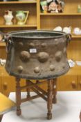 A COPPER CAULDRON ON STAND