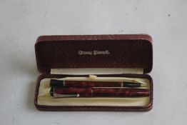 A CONWAY STEWART BOXED SET, A UNIVERSAL 479 FOUNTAIN PEN AND MATCHING PENCIL, in red marble finish