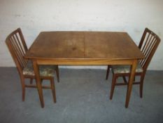 A TEAK EXTENDING DINING SET WITH TWO CHAIRS