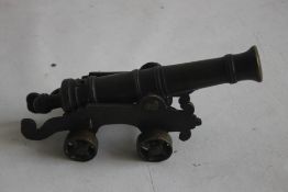 A SMALL ANTIQUE SIGNAL CANNON OF 18TH CENTURY STYLE, mounted on a brass carriage and wheels,