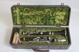 A CASED F. BUISSON B FLAT CLARINET, with cleaner and spare reeds, plate on case reads 