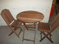 A WOODEN FOLDING PATIO TABLE SET WITH TWO CHAIRS