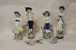 A COLLECTION OF FOUR GLAZED BISQUE STYLE FIGURES PLUS FOUR FLOWERS