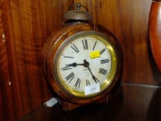 A SMALL ROUND MANTEL CLOCK BY GAMBLE WITH NOVELTY BELL ON TOP