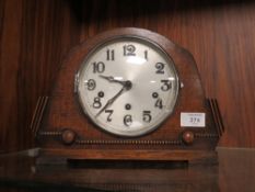 AN OAK MANTEL CLOCK