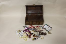 A WOODEN CASKET CONTAINING COSTUME JEWELLERY