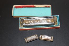 A CASED BANDMASTER MOUTH ORGAN TOGETHER WITH TWO HOHNER MOUTH ORGANS (3)