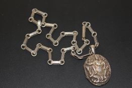 A SILVER EASTERN LOCKET ON WHITE METAL CHAIN
