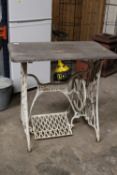 A GARDEN TABLE WITH A SINGER SEWING MACHINE TREADLE BASE