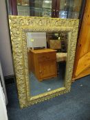 A MODERN GILT FRAMED WALL MIRROR 103 X 76 CM