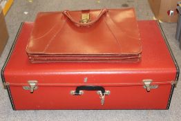 A RED RETRO STYLE SUITCASE AND A SATCHEL