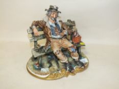 A CAPODIMONTE FIGURE OF A TRAMP ON A BENCH