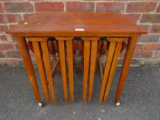 A RETRO NEST OF TEAK TABLES, AS FOUND, GENERAL MARKS AND SCRATCHES TOGETHER WITH A MUSICAL TABLE