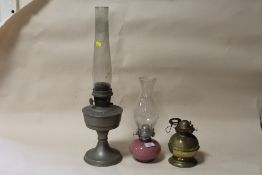 THREE ANTIQUE OIL LAMPS TO INCLUDE A PINK GLASS EXAMPLE