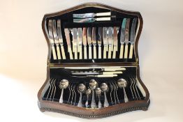A VINTAGE OAK CANTEEN OF CUTLERY WITH SHAPED BEADED DETAIL