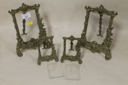 A PAIR OF BRASS PICTURE EASELS TOGETHER WITH A PAIR OF SMALLER EXAMPLES