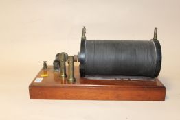 AN ANTIQUE VICTORIAN CONDUCTION COIL WITH BRASS FITTINGS ON MAHOGANY BASE, H 21, W 42, D 20 CM
