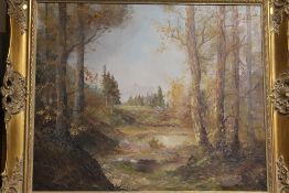 A GILT FRAMED OIL ON CANVAS OF A MOUNTAINOUS WOODED LANDSCAPE - OVERALL SIZE - 66CM X 75CM