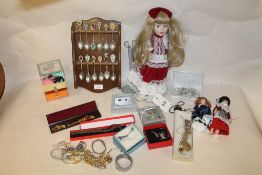 A BOX OF COSTUME JEWELLERY, MODERN DOLLS AND SOUVENIR SPOONS