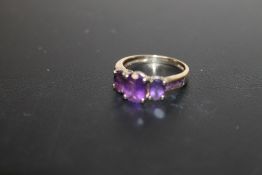 A HALLMARKED 9 CARAT GOLD THREE STONE AMETHYST RING, APPROX WEIGHT 2.7G