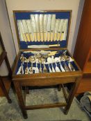 A SMALL OAK CASED CANTEEN OF EPNS CUTLERY ON STAND