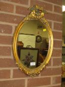 A CONTEMPORARY OVAL GILT WALL MIRROR - H 52 CM