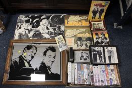 A QUANTITY OF LAUREL AND HARDY RELATED COLLECTABLES TO INCLUDE POSTERS, WALL MIRROR AND VHS TAPES