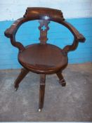 AN ANTIQUE OAK SWIVEL BOWED CHAIR ON BRASS CASTORS, MECHANISM TIGHT