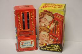 A VINTAGE CHOCOLATE SLOT MACHINE WITH ORIGINAL CHOCOLATE