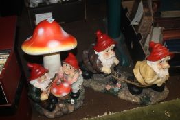 A GARDEN GNOME FIGURE GROUP TOGETHER WITH A TOADSTOOL