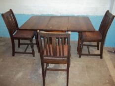 AN ANTIQUE OAK DROP LEAF DINING TABLE AND THREE CHAIRS