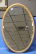 A OVAL GILT FRAMED MIRROR 64 CM X 94 CM