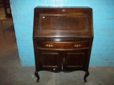 AN OAK DROP DOWN BUREAU IN ARTS & CRAFTS STYLE