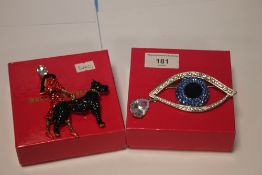 BUTLER AND WILSON TWO BOXED BROOCHES, ONE A LARGE BLUE EYE THE OTHER A LADY AND DOG