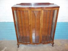 A VINTAGE SERPENTINE FRONTED CHINA DISPLAY CABINET (ONE CRACKED GLASS PANE)