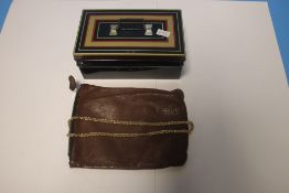A SMALL VINTAGE CASH TIN CONTAINING A YELLOW METAL CHAIN