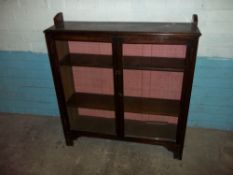 AN OAK ANTIQUE GLAZED LOCKING BOOKCASE