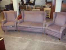 A FABRIC TWO SEATER THREE PIECE SUITE WITH BRASS CASTORS