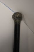 A WHITE METAL TOPPED EBONISED WALKING CANE